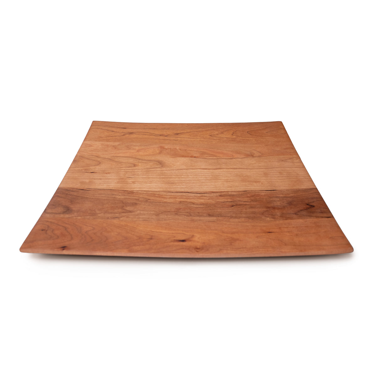 Square cherry wood serving platter with slightly curved edges and natural grain patterns.