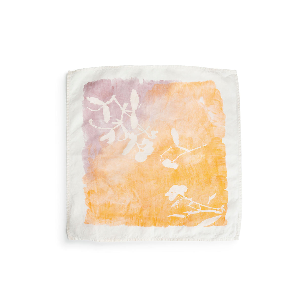 Cream linen napkin with apricot and mauve watercolor wash and white botanical leaf print.