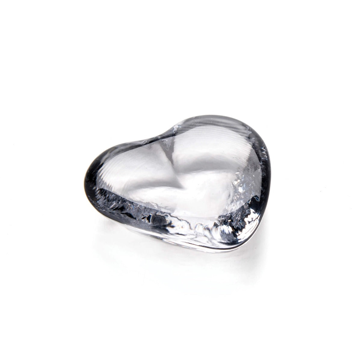 Clear glass heart-shaped object with smooth curved surface and reflective finish.