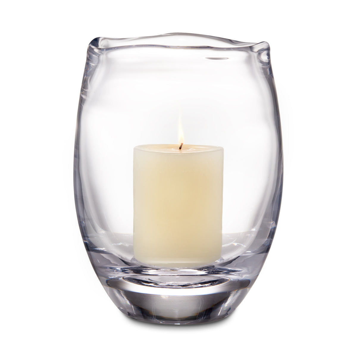 Clear glass hurricane vase with curved sides holding a cream-colored pillar candle with lit wick.