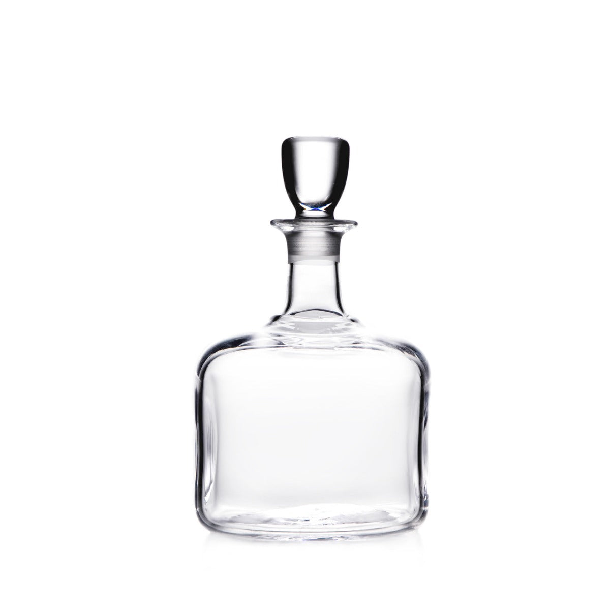Clear glass decanter with rounded rectangular body, narrow neck, and matching glass stopper.