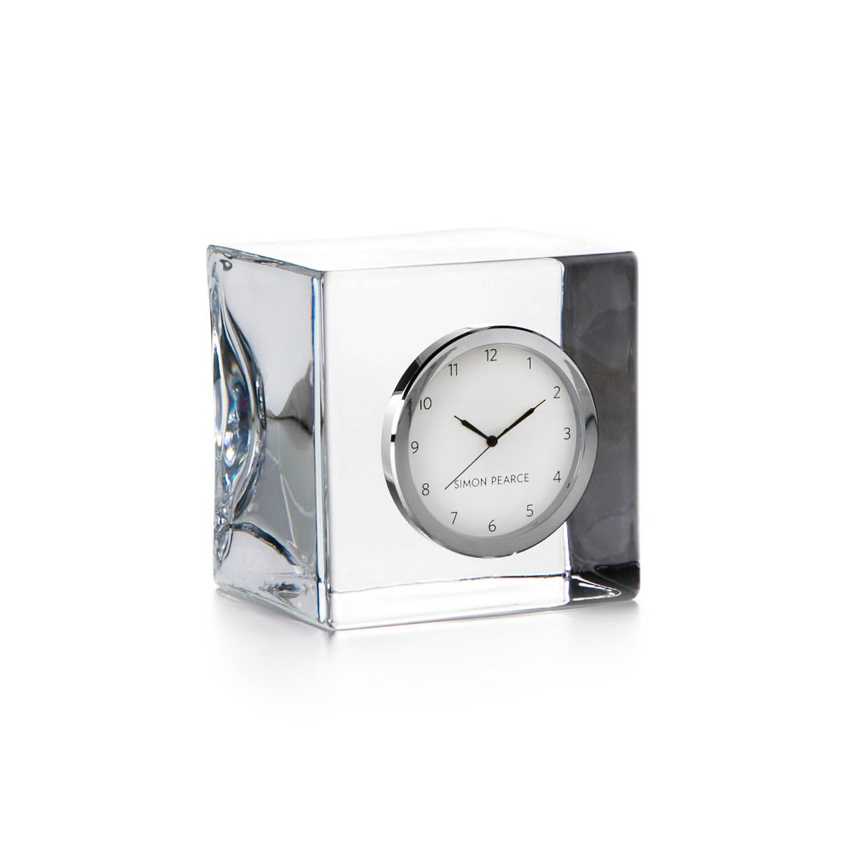 Clear glass cube desk clock with white face, silver-tone bezel, black hands, and "Simon Pearce" branding.