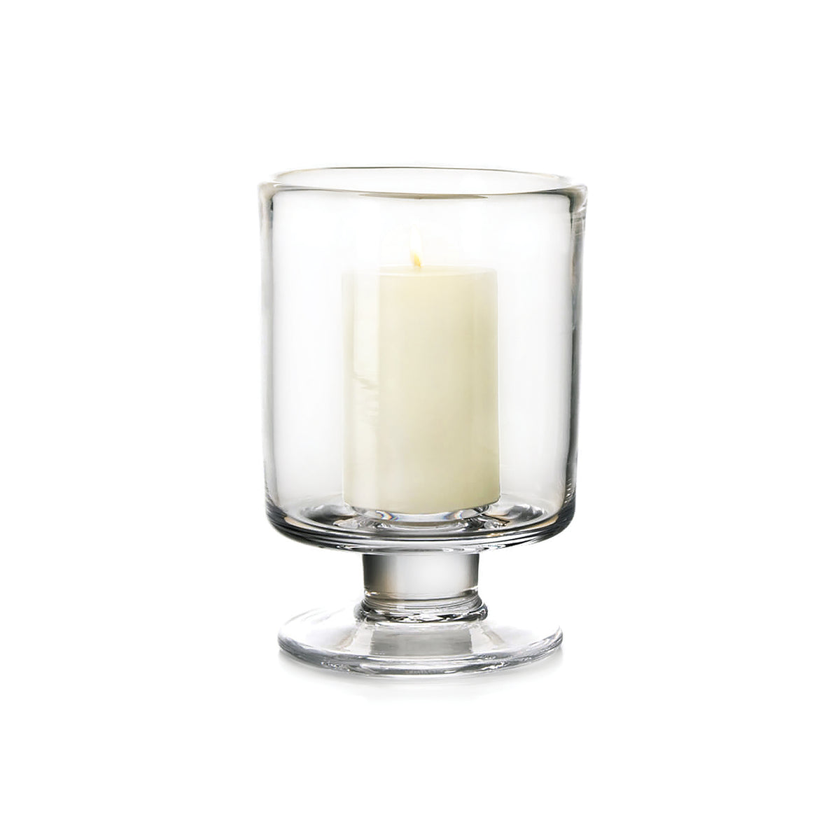 Clear glass hurricane vase with pedestal base containing a cream-colored pillar candle.