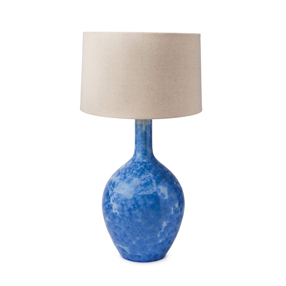 Blue crystalline ceramic table lamp with beige linen drum shade.