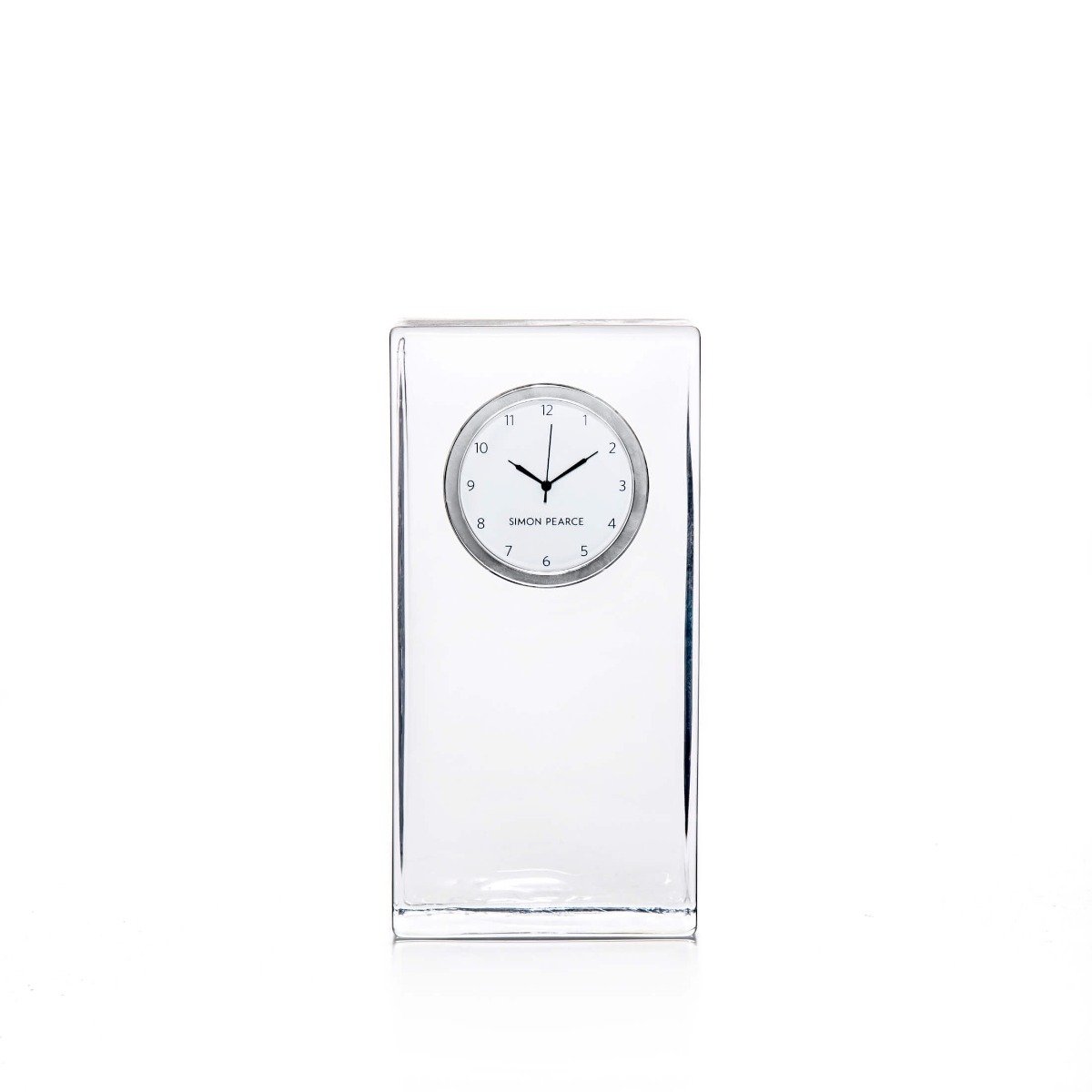 Tall rectangular clear glass clock with round dial face and black hands, Simon Pearce brand marking visible.