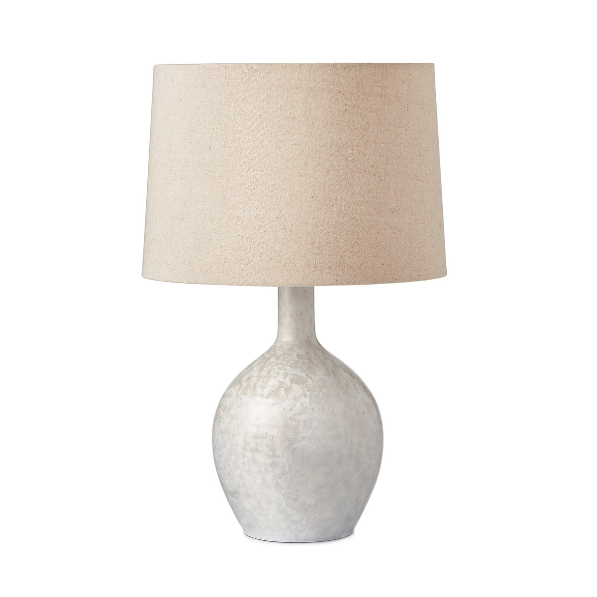 Table lamp with textured white ceramic base and taupe linen drum shade.