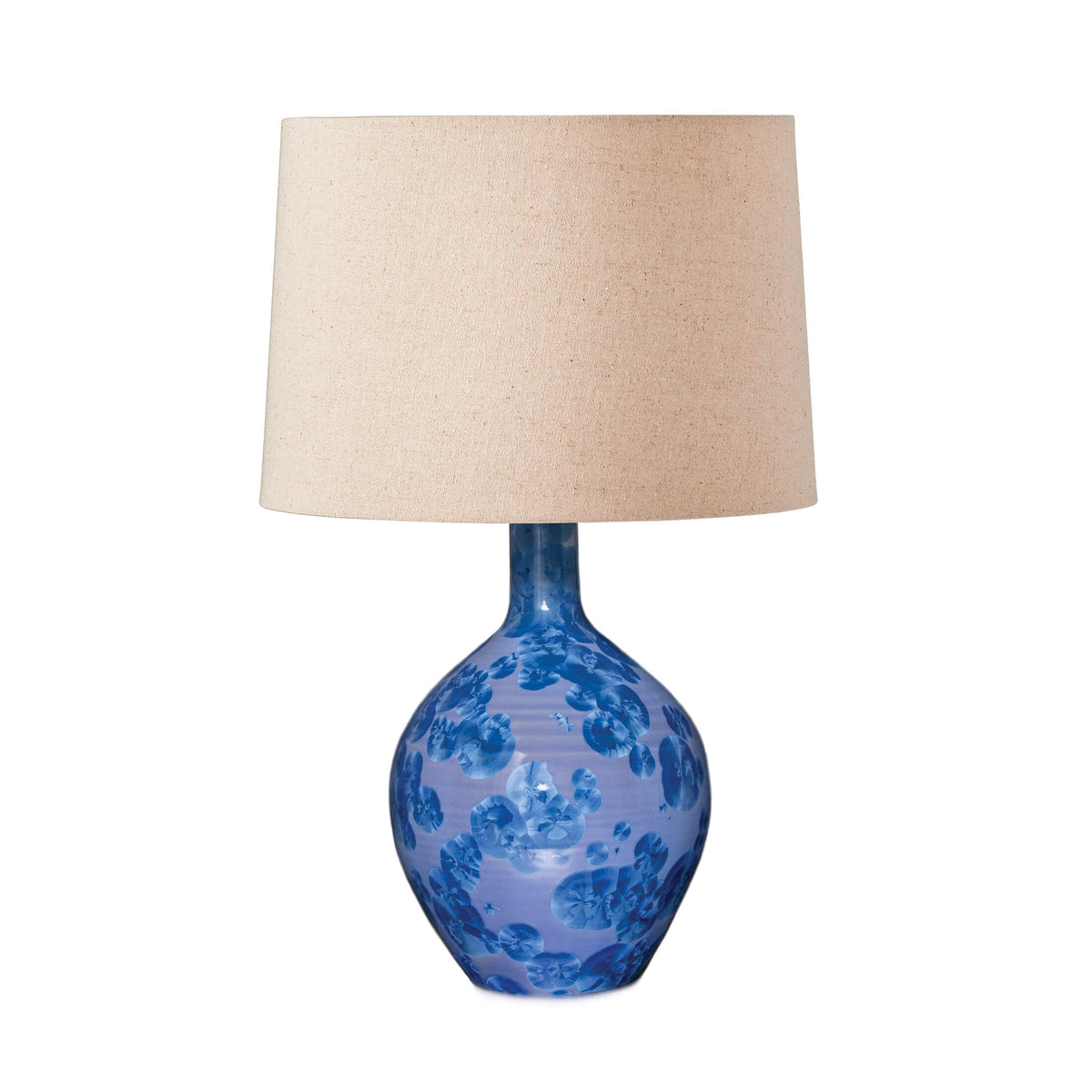 Blue ceramic base with floral pattern and beige linen drum shade.