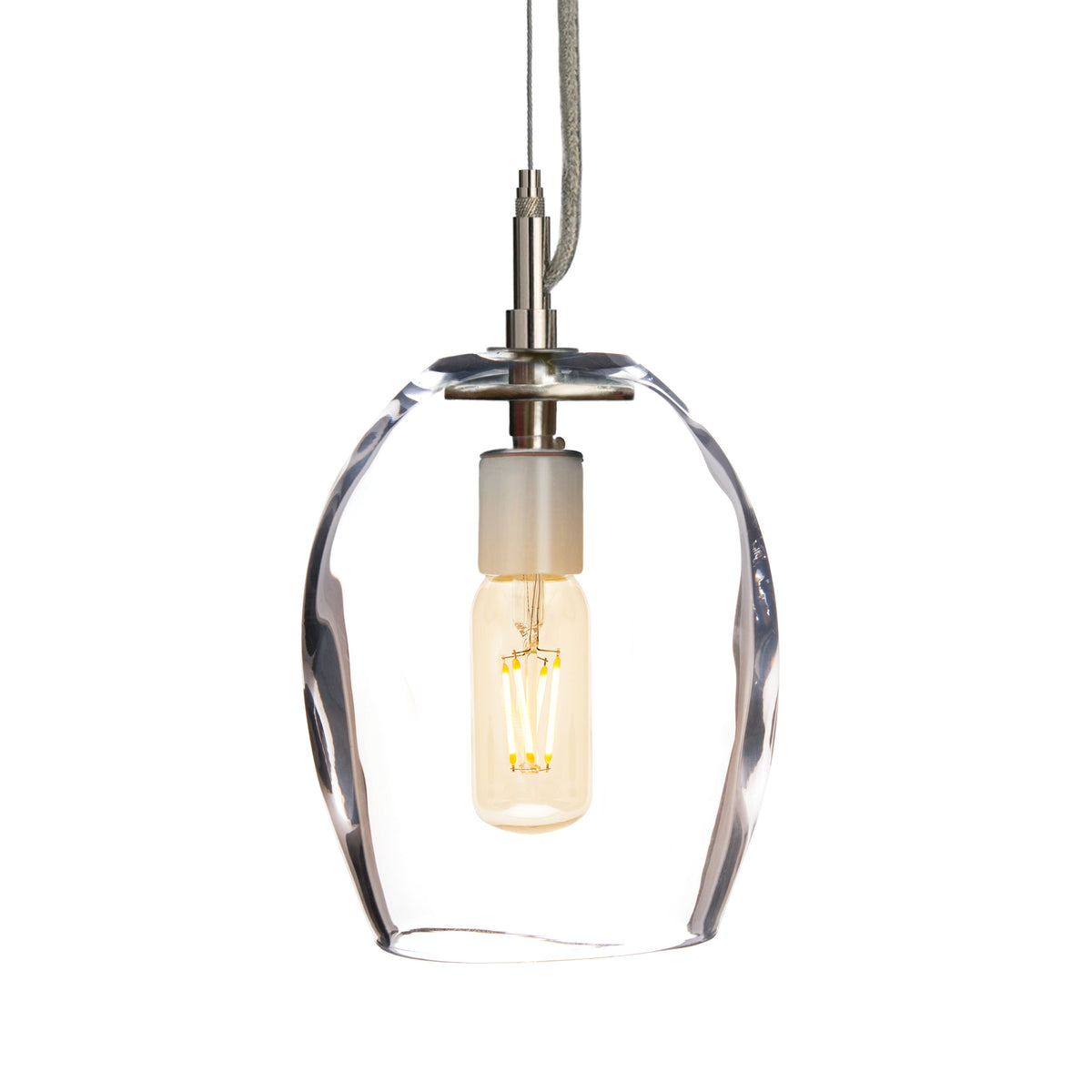 Pendant light with clear glass shade, brass fixture, and illuminated filament bulb suspended from gray cord.