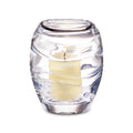 Clear glass hurricane candle holder with cream-colored pillar candle inside and horizontal ridged texture.