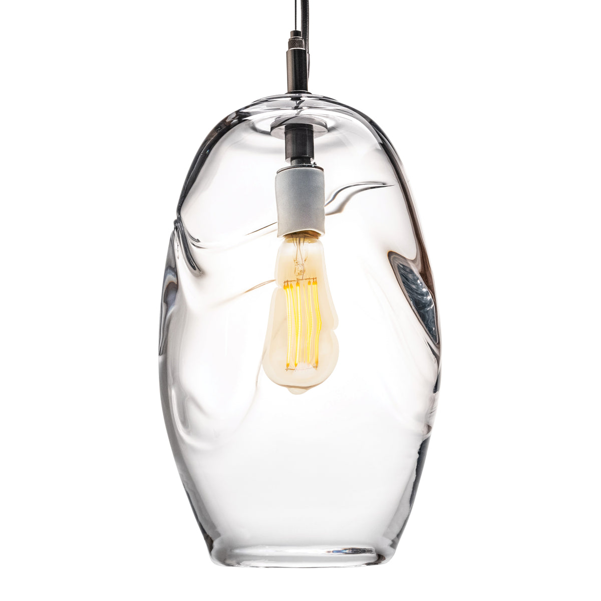 Clear glass pendant with organic shape, black cord, and lit filament bulb inside.