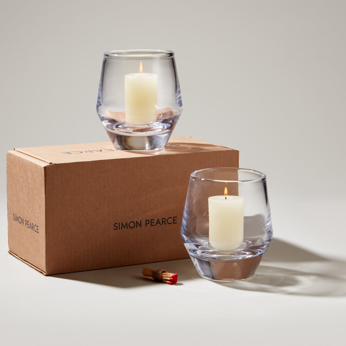 Bristol Hurricane Set in gift box with two clear glass candle holders containing cream pillar candles and matches.