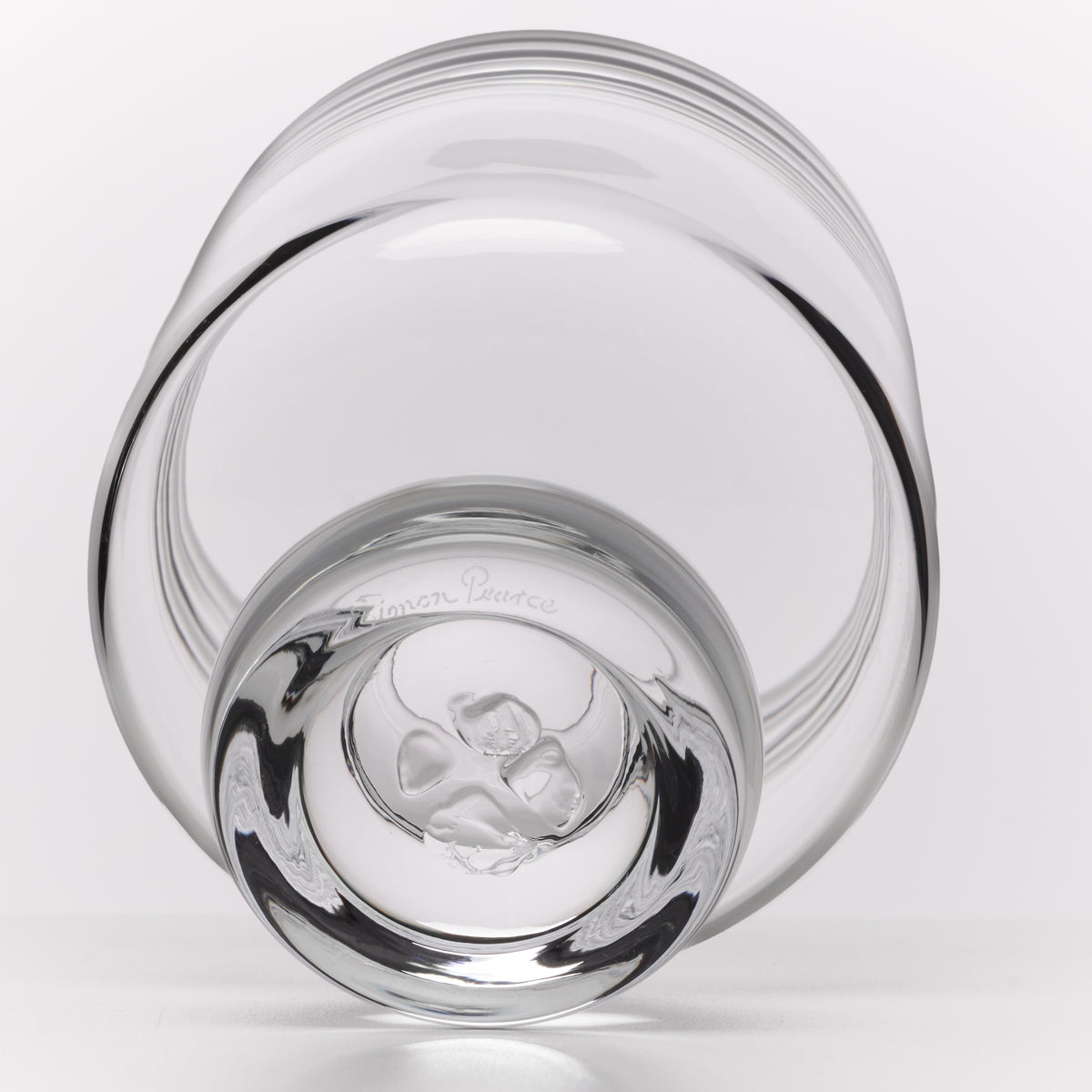 A clear glass bowl with a thick, rounded base, photographed on a clean white background.