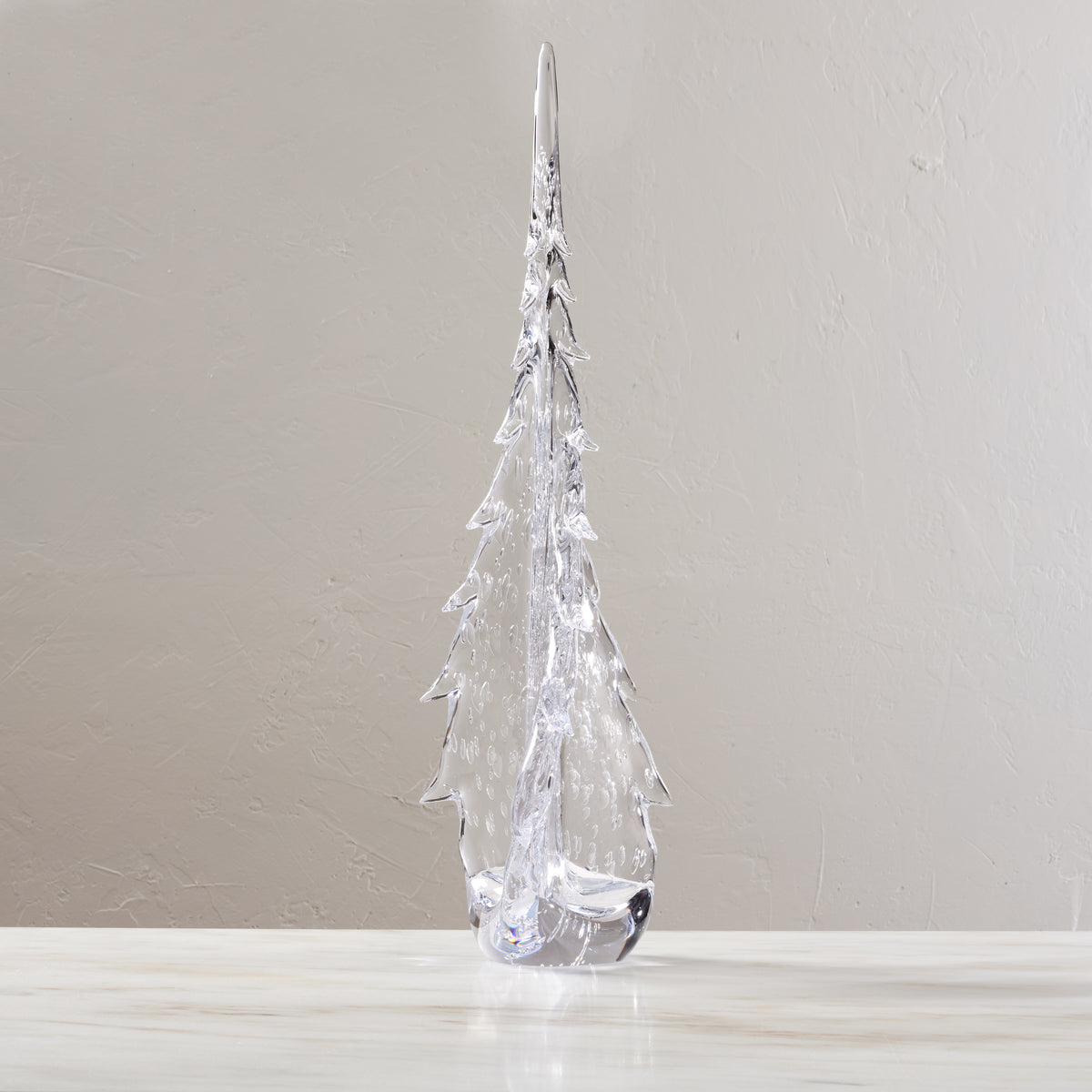 Clear glass twisted evergreen tree sculpture, 26 inches tall, with textured surface detail.
