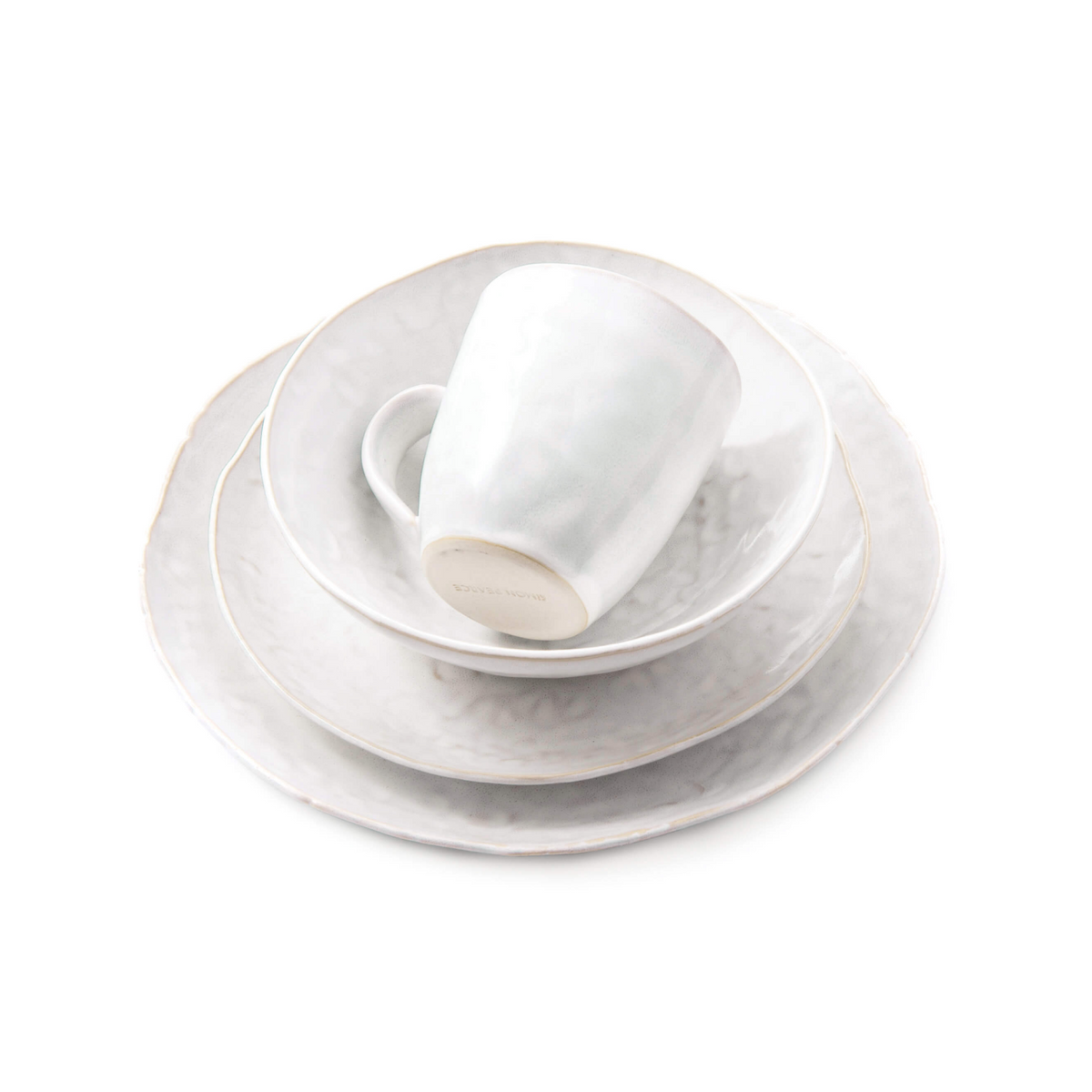 White dinnerware set with stacked plates, bowl, and mug featuring cloud-like surface texture.
