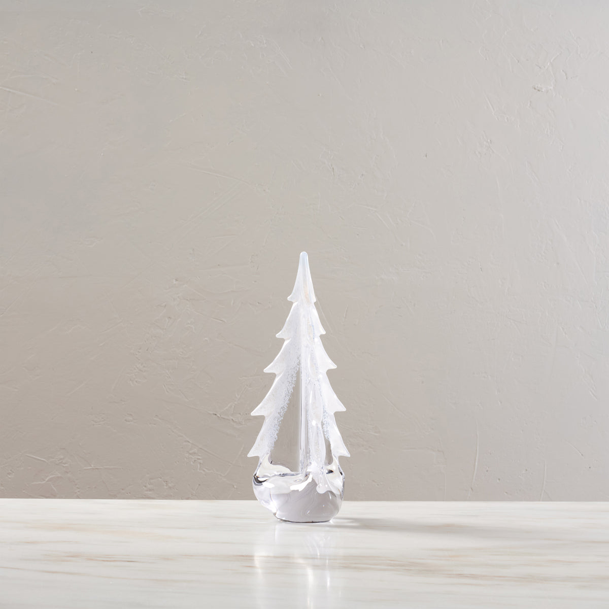 White evergreen tree decoration with snow coating and white base, 12 inches tall.