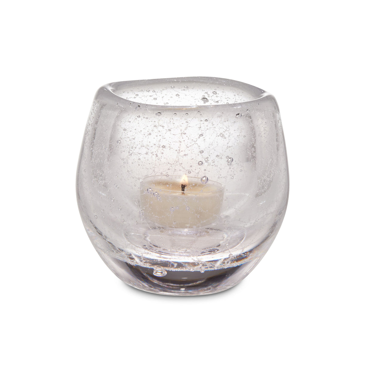 Clear glass tealight holder with cream-colored tealight candle inside.
